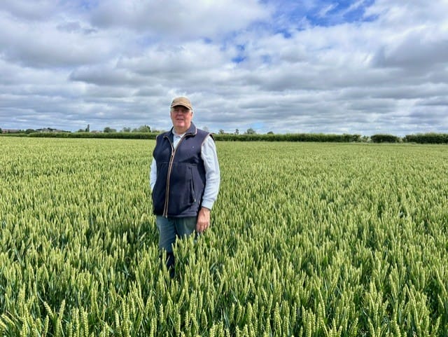 Richard stood in a field of crops